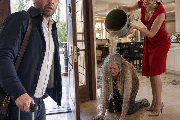 Ik kwam thuis uit de VS met een koffer vol cadeaus en een hart vol vertrouwen. De deur was niet eens op slot. Ik hoorde de stem van mijn vrouw – koud, scherp: “Sneller. Doe niet zo oud in mijn huis.” Toen sneed de trillende reactie van mijn moeder door me heen: “Alsjeblieft… mijn handen doen pijn.” Ik stond als versteend in de gang en keek toe hoe ze de vloer schrobde als een dienstmeisje. Mijn maag draaide zich om. Mijn vrouw draaide zich om, glimlachte en zei: “Oh… je bent vroeg.” En toen besefte ik het – dit was niet de eerste keer.